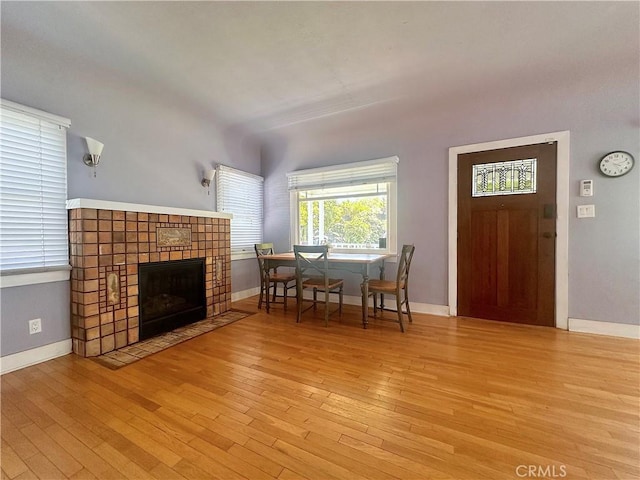 551 W Walnut Ave, Monrovia, CA 91016 - dining room featuring wood finished floors, a tiled fireplace, and baseboards