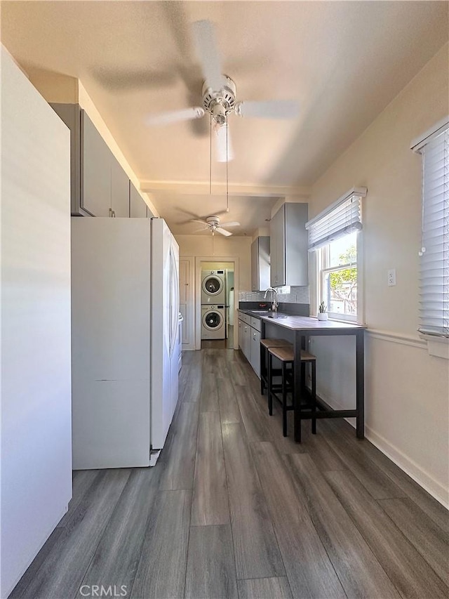 551 W Walnut Ave, Monrovia, CA 91016 - kitchen featuring estacked washer and dryer, freestanding refrigerator, a ceiling fan, dark wood finished floors, and a sink