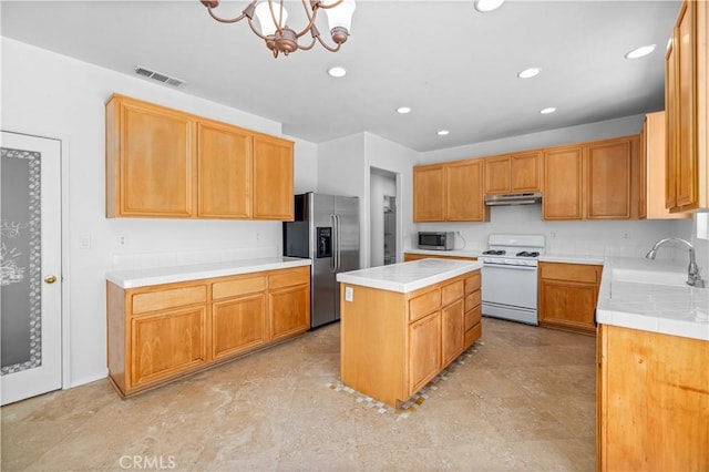 kitchen with appliances with stainless steel finishes, a sink, under cabinet range hood, a center island, and recessed lighting