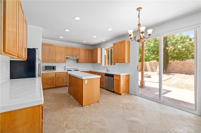 kitchen with stainless steel appliances, under cabinet range hood, a chandelier, light countertops, and recessed lighting