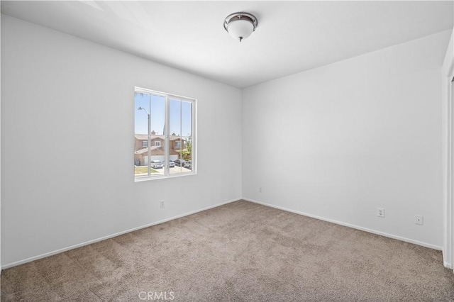 carpeted spare room with baseboards