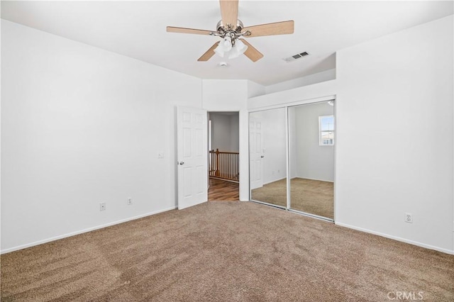 unfurnished bedroom featuring carpet, baseboards, a closet, and ceiling fan