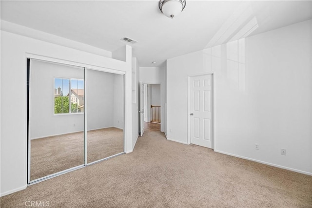 unfurnished bedroom featuring carpet, a closet, and baseboards