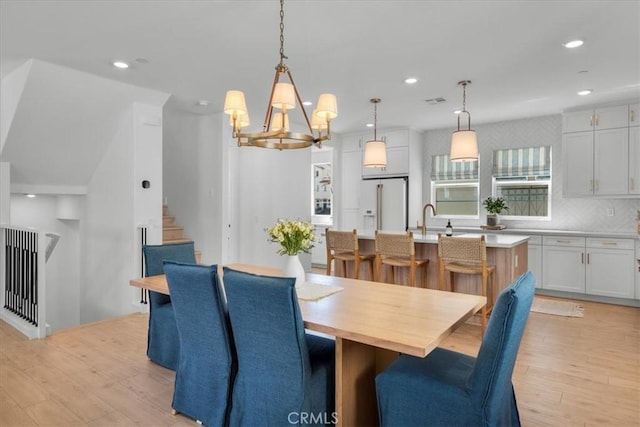 27659 S Rosewood Ln, San Pedro, CA 90732 - dining space featuring light wood-type flooring, a chandelier, recessed lighting, and stairs