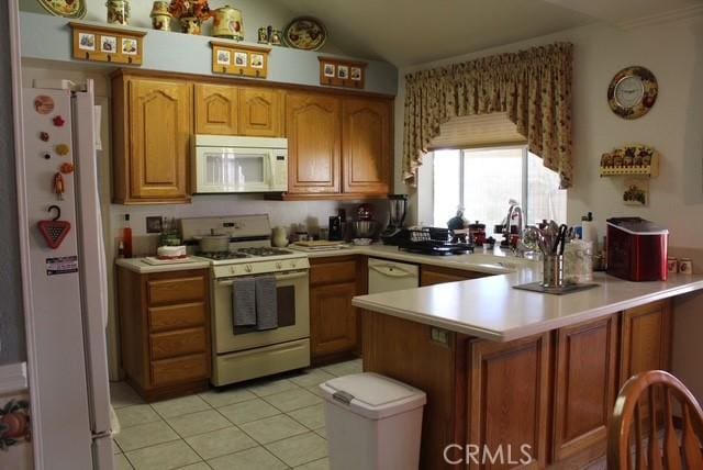 12601 Heartleaf St, Moreno Valley, CA 92553 - kitchen with white appliances, a peninsula, a sink, light countertops, and light tile patterned floors