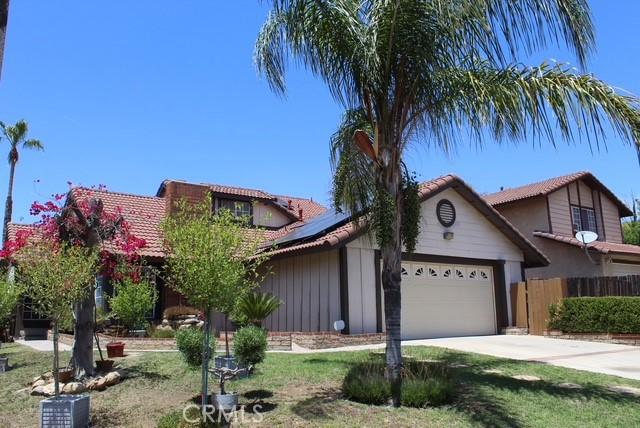 12601 Heartleaf St, Moreno Valley, CA 92553 - view of front of property featuring an attached garage, solar panels, a tiled roof, and driveway