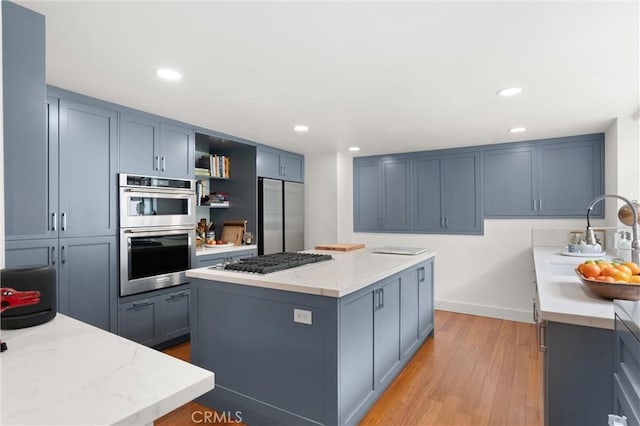 645 Griffith Way, Laguna Beach, CA 92651 - kitchen with appliances with stainless steel finishes, a sink, light wood-type flooring, a kitchen island, and open shelves