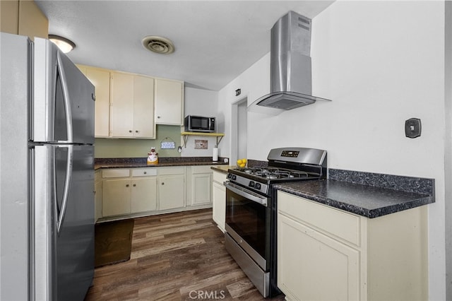 1980 N Sierra Way, San Bernardino, CA 92405 - kitchen with stainless steel appliances, wall chimney range hood, dark wood-style floors, dark countertops, and cream cabinetry