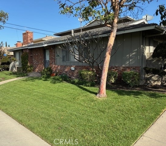 13181 Balboa Ave, Garden Grove, CA 92840 - view of side of property with a yard, board and batten siding, and a chimney
