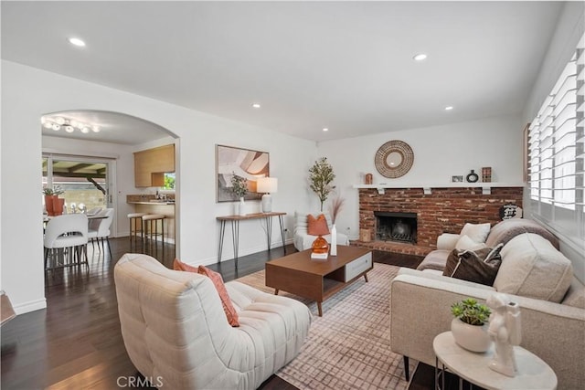 6028 Hart Ave, Temple City, CA 91780 - living area featuring healthy amount of natural light, dark wood-type flooring, a fireplace, arched walkways, and recessed lighting