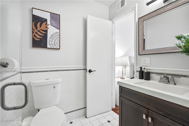 6028 Hart Ave, Temple City, CA 91780 - bathroom featuring tile walls, toilet, vanity, a wainscoted wall, and tile patterned floors