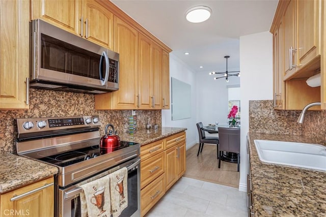 1115 S Elm Dr Unit 510, Los Angeles, CA 90035 - kitchen with stainless steel appliances, a sink, backsplash, light stone counters, and recessed lighting