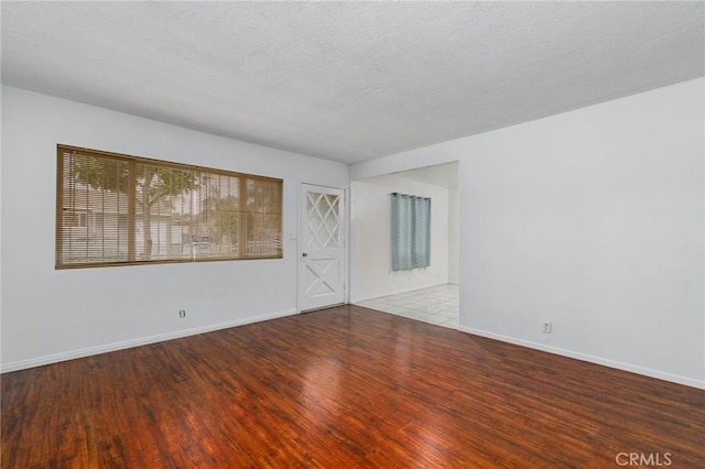 empty room with wood finished floors and baseboards