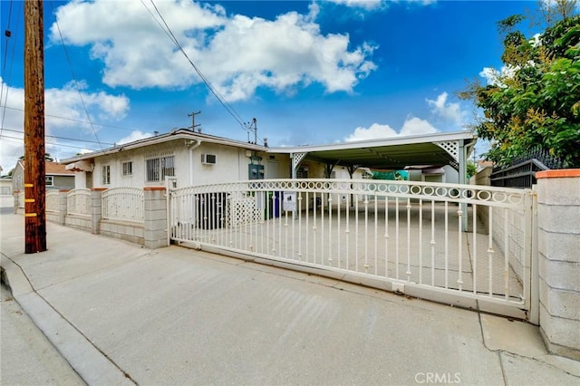 view of front of house featuring a fenced front yard, a gate, and stucco siding