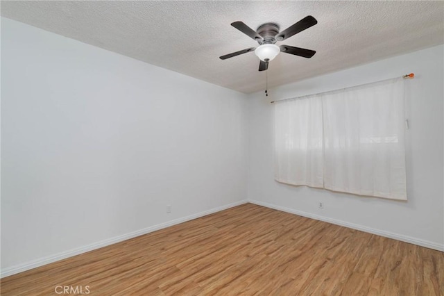 empty room with light wood finished floors, a textured ceiling, baseboards, and a ceiling fan