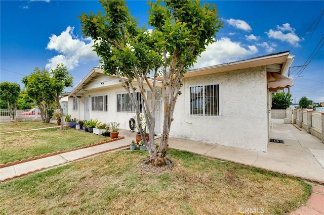 bungalow-style house featuring stucco siding and a patio