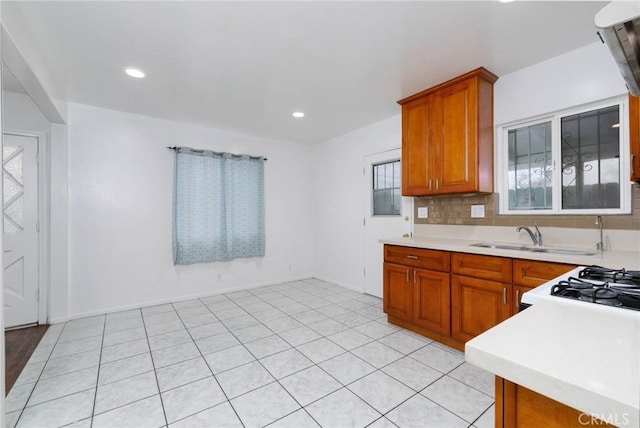 kitchen featuring light countertops, brown cabinetry, healthy amount of natural light, and recessed lighting