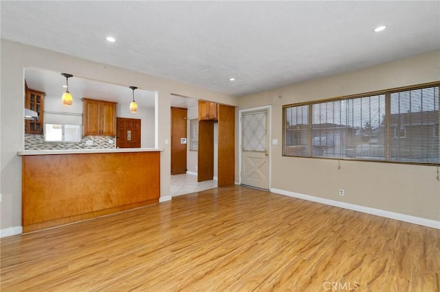 unfurnished living room with light wood finished floors, baseboards, and recessed lighting