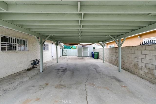 view of patio featuring a fenced backyard, a carport, and a storage unit