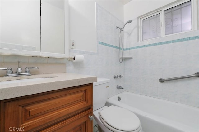 full bath featuring toilet, bathing tub / shower combination, vanity, and tile walls