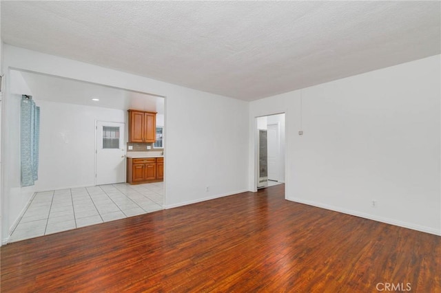 unfurnished living room with light wood-style flooring and baseboards