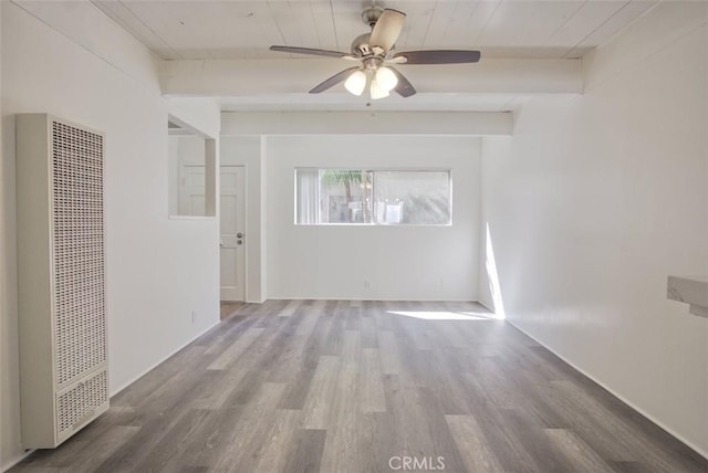 spare room featuring a heating unit, a ceiling fan, and wood finished floors
