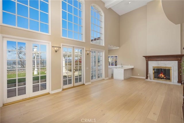 3211 E Mandeville Pl, Orange, CA 92867 - unfurnished living room featuring a high ceiling, light wood-type flooring, a premium fireplace, and baseboards