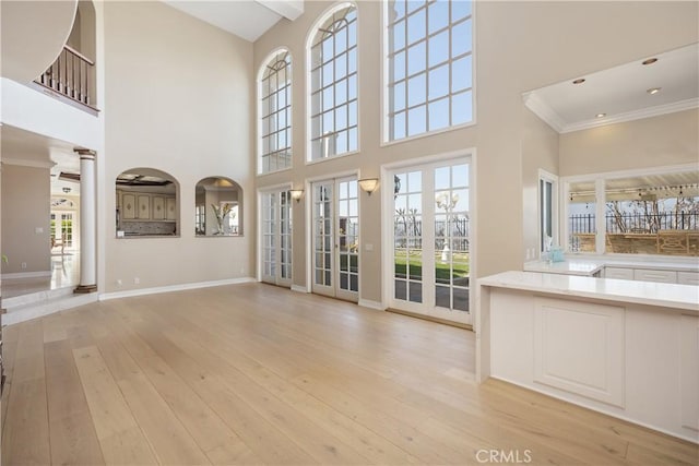 3211 E Mandeville Pl, Orange, CA 92867 - unfurnished living room with a towering ceiling, ornamental molding, light wood-type flooring, and baseboards