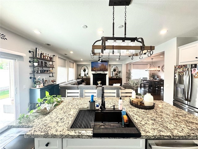 4772 Marrieta St, Jurupa Valley, CA 91752 - kitchen featuring stainless steel fridge, white cabinetry, open floor plan, a chandelier, and a sink