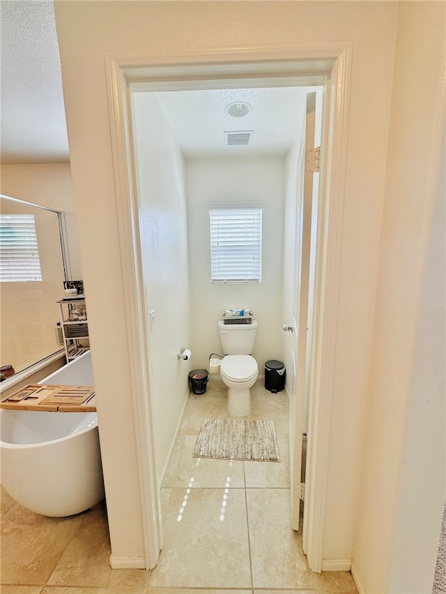 4772 Marrieta St, Jurupa Valley, CA 91752 - bathroom featuring tile patterned flooring, toilet, a freestanding tub, and baseboards