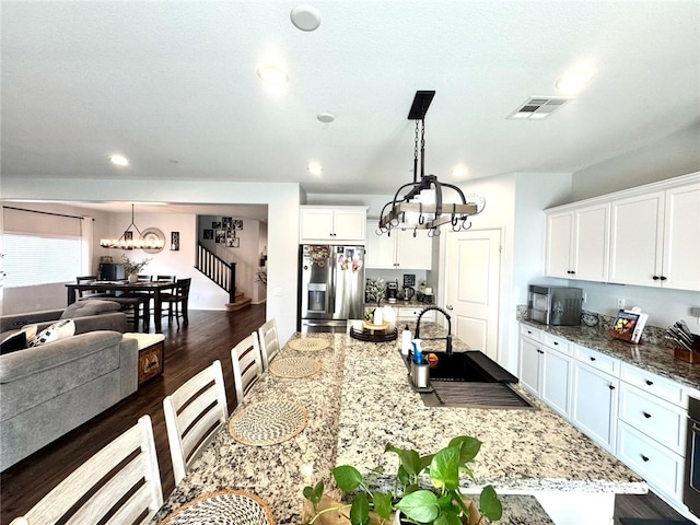 4772 Marrieta St, Jurupa Valley, CA 91752 - kitchen featuring stainless steel fridge with ice dispenser, a chandelier, a sink, white cabinets, and light stone counters