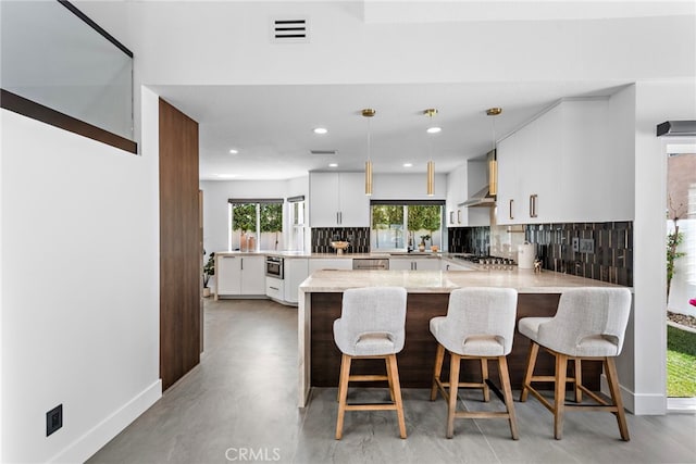 11 Bayside, Irvine, CA 92614 - kitchen with tasteful backsplash, a peninsula, wall chimney exhaust hood, baseboards, and recessed lighting