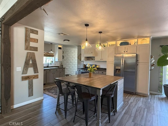 17857 Main St, Hesperia, CA 92345 - kitchen with stainless steel appliances, a sink, dark wood finished floors, baseboards, and decorative light fixtures