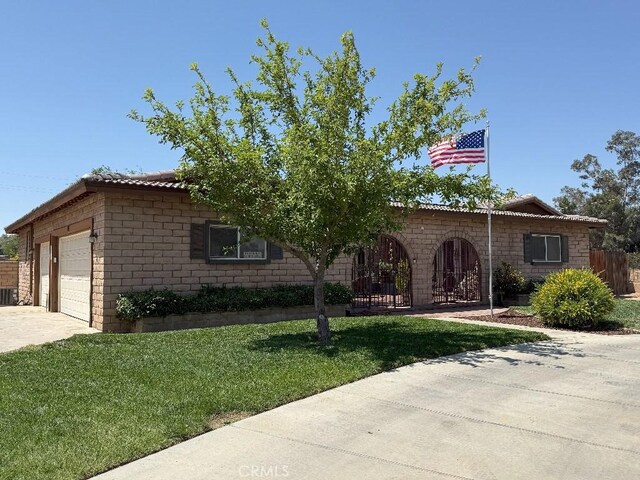 17857 Main St, Hesperia, CA 92345 - view of front of home with a front lawn, an attached garage, driveway, and central air condition unit
