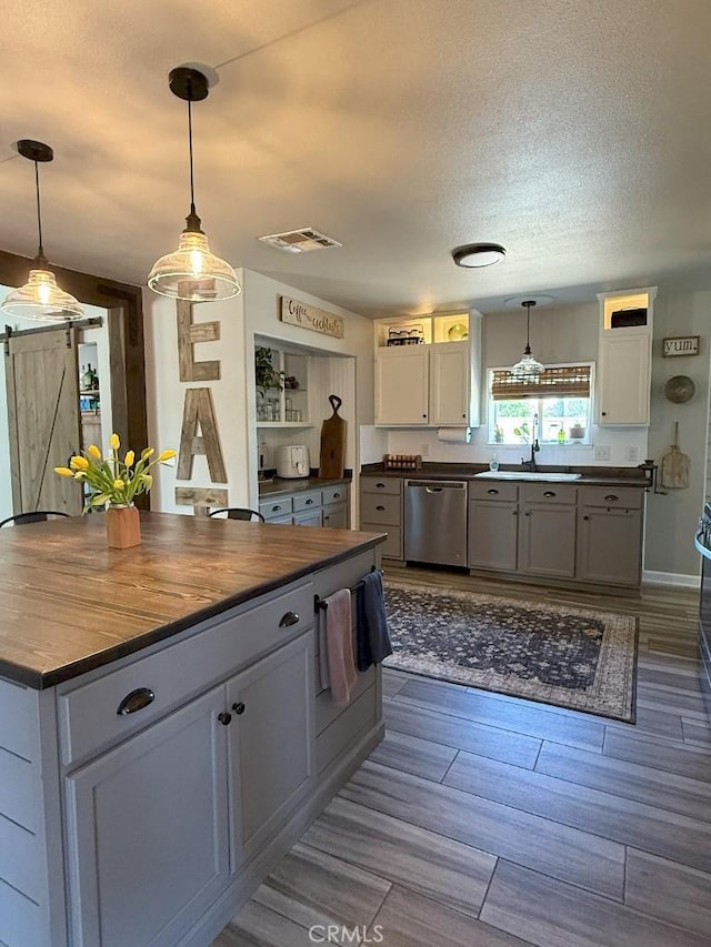 17857 Main St, Hesperia, CA 92345 - kitchen with stainless steel dishwasher, a sink, pendant lighting, white cabinets, and a textured ceiling