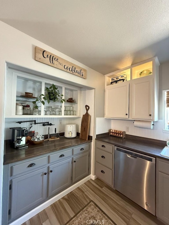 17857 Main St, Hesperia, CA 92345 - kitchen with stainless steel dishwasher, dark countertops, open shelves, wood finished floors, and a textured ceiling