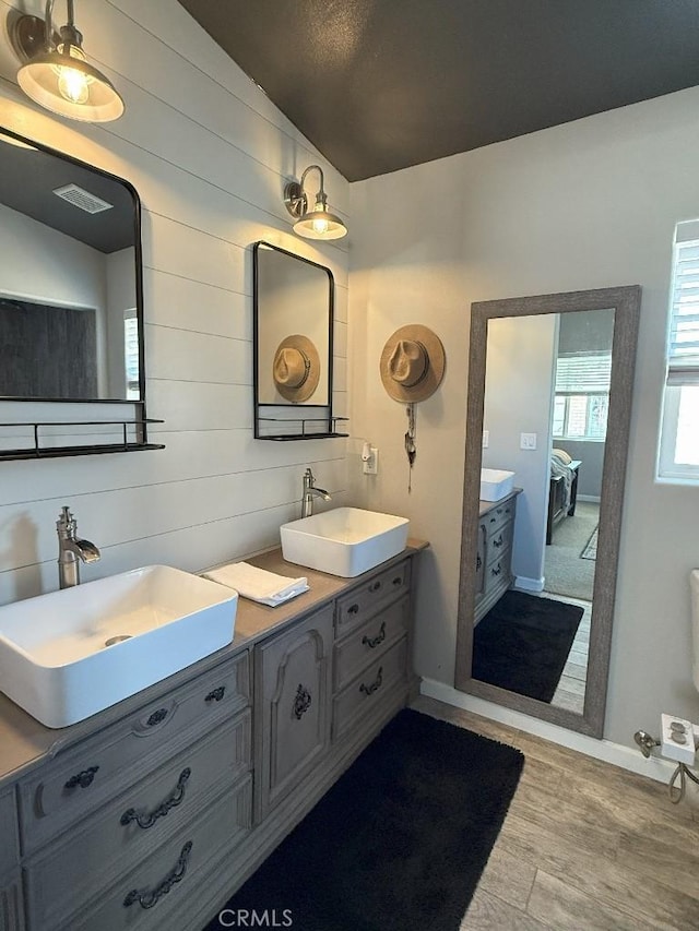 17857 Main St, Hesperia, CA 92345 - full bathroom with double vanity, wood finished floors, ensuite bathroom, wooden walls, and baseboards