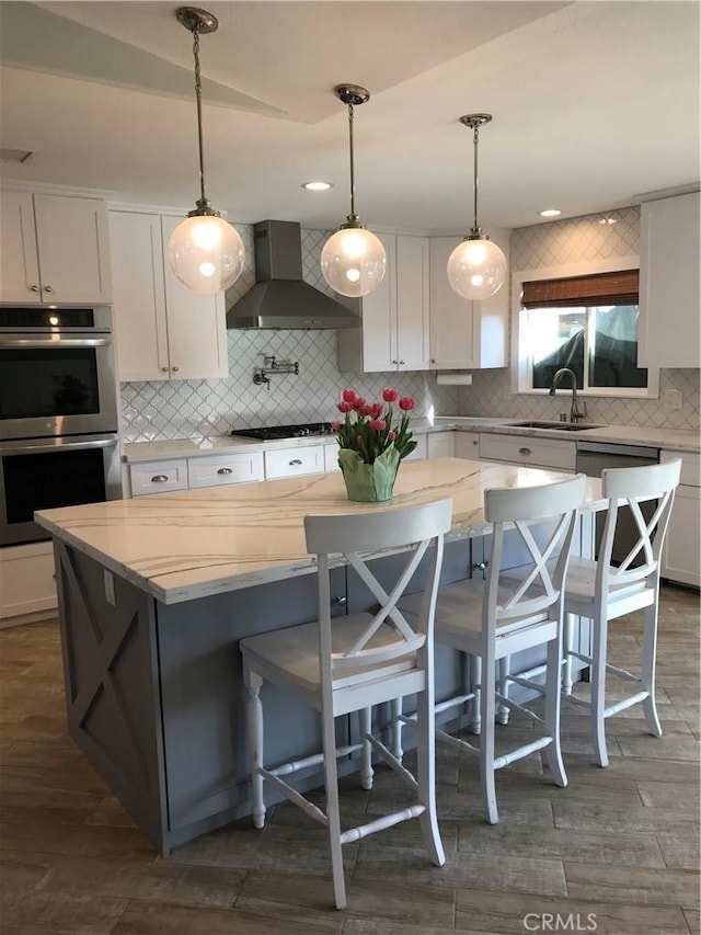 26021 Crestmont Cir, Menifee, CA 92586 - kitchen featuring stainless steel double oven, wall chimney exhaust hood, gas stovetop, backsplash, and white cabinetry
