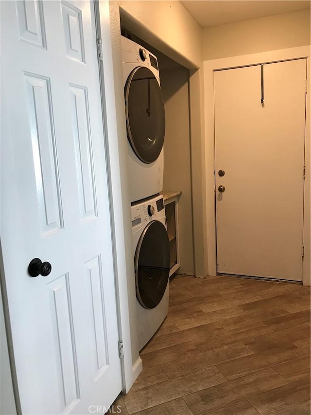 26021 Crestmont Cir, Menifee, CA 92586 - laundry area with stacked washer / dryer and wood finished floors