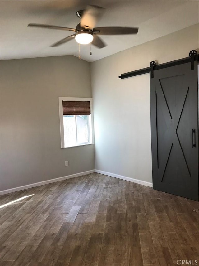 26021 Crestmont Cir, Menifee, CA 92586 - spare room with ceiling fan, vaulted ceiling, dark wood finished floors, a barn door, and baseboards