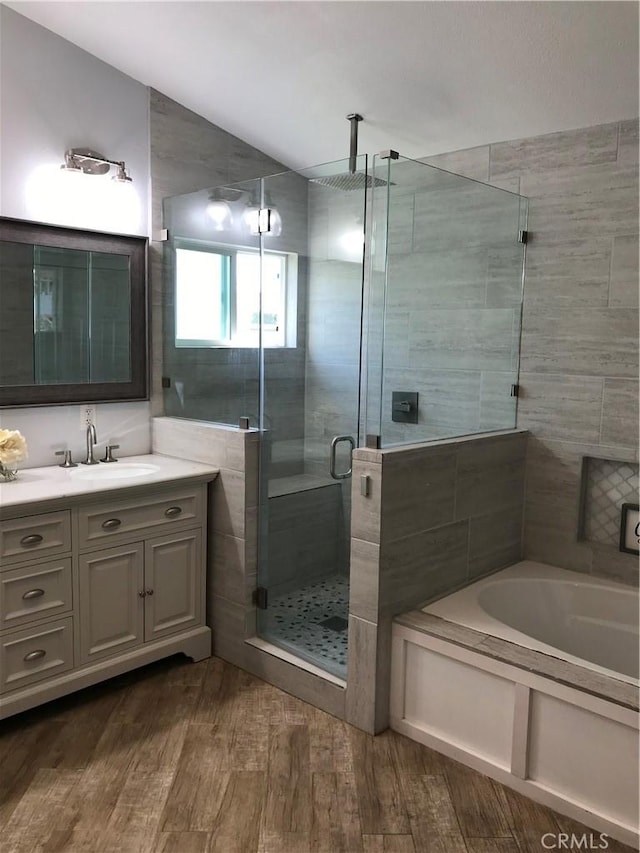 26021 Crestmont Cir, Menifee, CA 92586 - bathroom featuring wood finished floors, a garden tub, vanity, and a shower stall