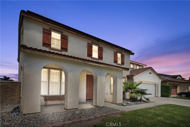7311 Pinewood Ct, Eastvale, CA 92880 - mediterranean / spanish house with driveway, stucco siding, an attached garage, and covered porch