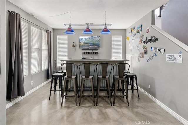 7311 Pinewood Ct, Eastvale, CA 92880 - indoor dry bar with baseboards, finished concrete floors, and hanging light fixtures
