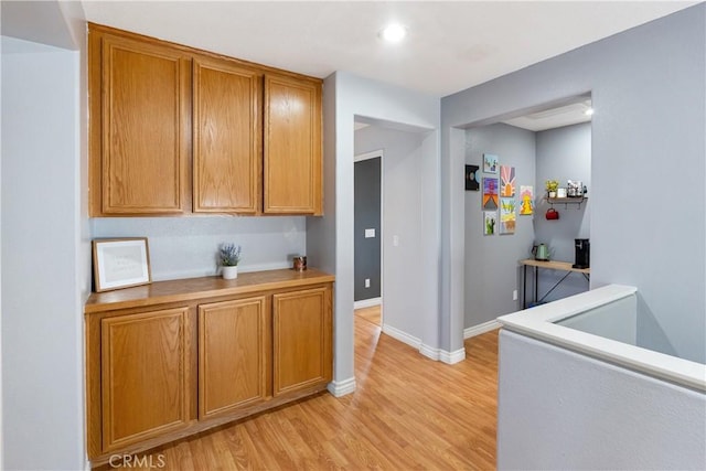 7311 Pinewood Ct, Eastvale, CA 92880 - kitchen featuring light wood-style floors, brown cabinets, light countertops, baseboards, and recessed lighting