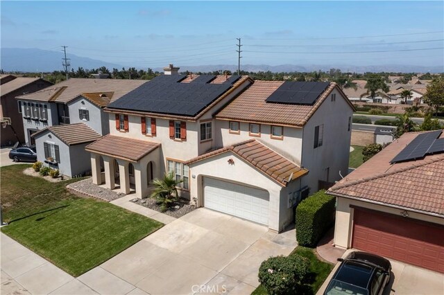 7311 Pinewood Ct, Eastvale, CA 92880 - mediterranean / spanish-style home featuring a tile roof, stucco siding, concrete driveway, roof mounted solar panels, and a residential view