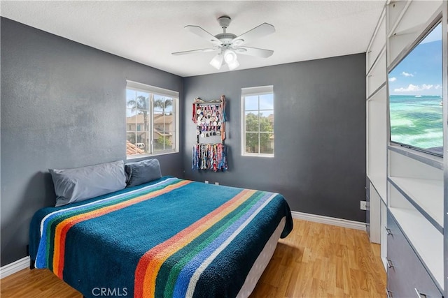 7311 Pinewood Ct, Eastvale, CA 92880 - bedroom with light wood-style floors, multiple windows, baseboards, and ceiling fan