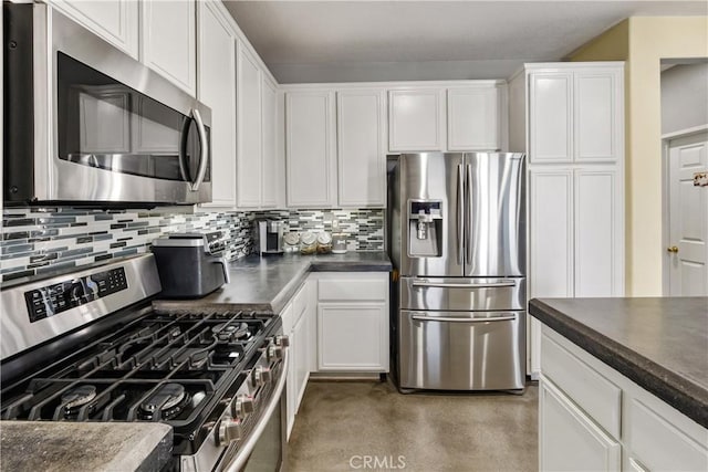 7311 Pinewood Ct, Eastvale, CA 92880 - kitchen featuring stainless steel appliances, dark countertops, white cabinets, tasteful backsplash, and concrete flooring