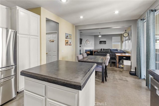 7311 Pinewood Ct, Eastvale, CA 92880 - kitchen with freestanding refrigerator, dark countertops, a center island, open floor plan, and white cabinetry