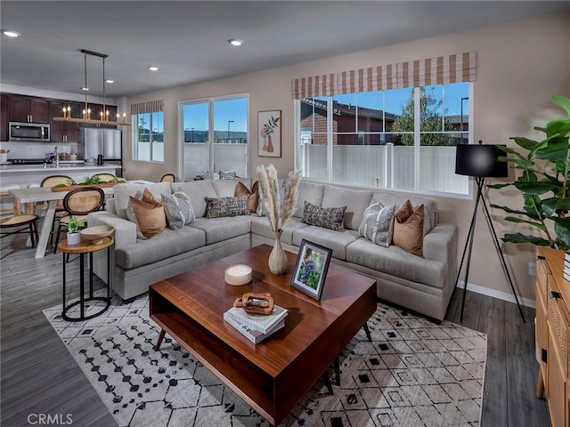 living room with recessed lighting, baseboards, and light wood-style flooring