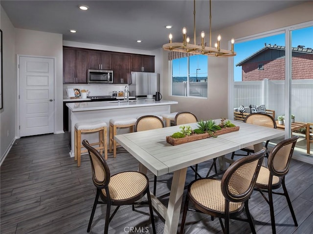 dining room featuring dark wood finished floors, recessed lighting, baseboards, and a chandelier